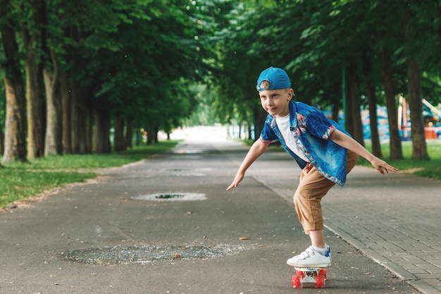 Un ragazzo di piccola città andskateboard. Un giovane ragazzo sta cavalcando uno skateboard parka