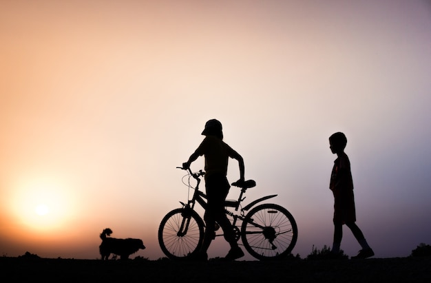 Un ragazzo e donna idoneità silhouette alba ciclismo concetto di allenamento allenamento.