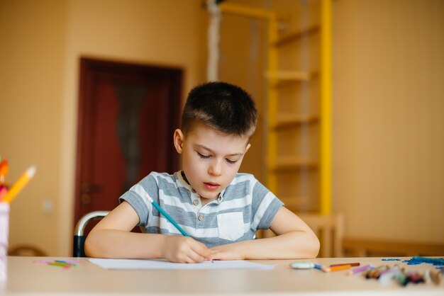 Un ragazzo in età scolare fa i compiti a casa. Allenarsi a scuola.