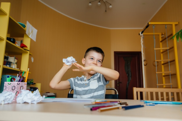 Un ragazzo in età scolare fa i compiti a casa. Allenarsi a scuola.