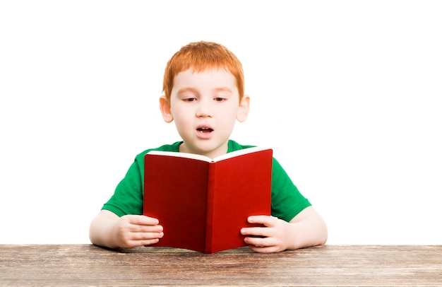 Un ragazzo legge il libro rosso, il ritratto di un bambino che impara da solo