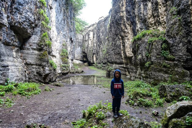 Un ragazzo nella gola di Stone Bowl Una gola tra le montagne della natura del paesaggio del Daghestan Russia