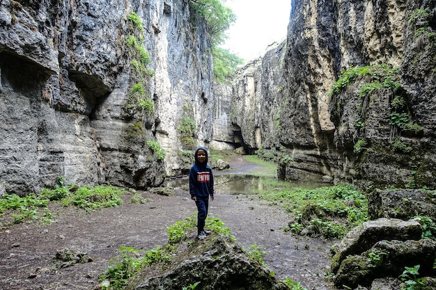 Un ragazzo nella gola di Stone Bowl Una gola tra le montagne della natura del paesaggio del Daghestan Russia