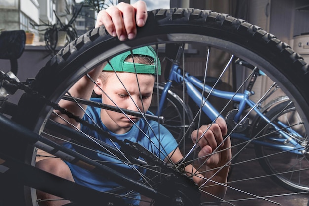 Un ragazzo ripara una bicicletta