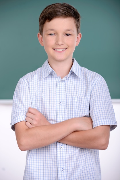 Un ragazzo sta con la mano insieme a scuola.