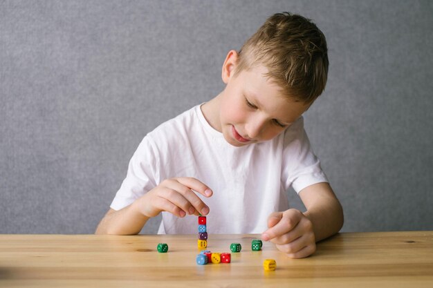 Un ragazzo sta giocando con cubi colorati che costruiscono una torre