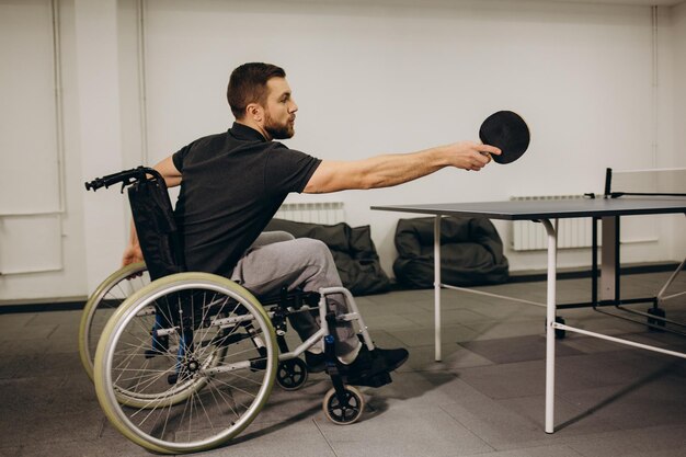 Un ragazzo su una sedia a rotelle gioca a ping pong