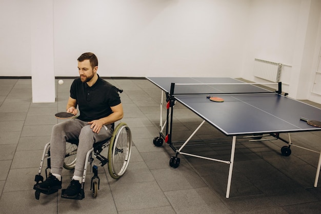 Un ragazzo su una sedia a rotelle gioca a ping pong