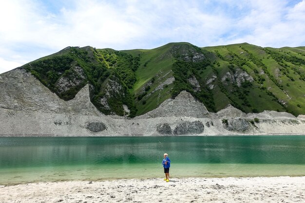 Un ragazzo sullo sfondo del lago Kezenoyam nelle montagne del Caucaso in Cecenia Russia giugno 2021