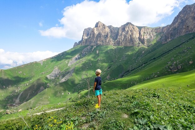 Un ragazzo sullo sfondo del verde paesaggio del passo di Aktoprak nel Caucaso Russia giugno 2021