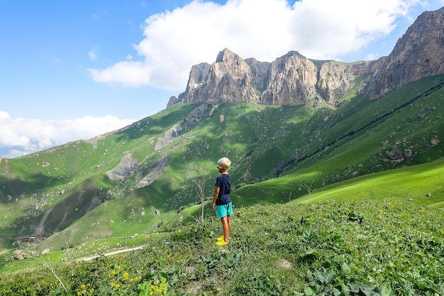 Un ragazzo sullo sfondo del verde paesaggio del passo di Aktoprak nel Caucaso Russia giugno 2021