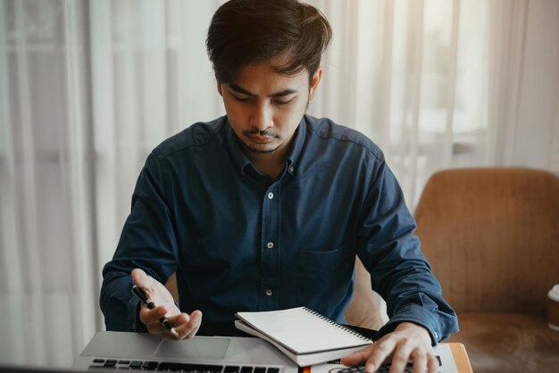 Un ragioniere d'affari maschio professionista di successo dall'aspetto piacevole apprende che il caso dei clienti funziona su un laptop moderno