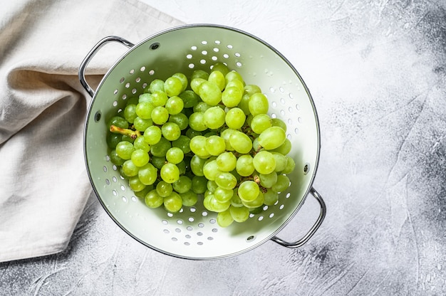 Un ramo di uva matura verde in uno scolapasta