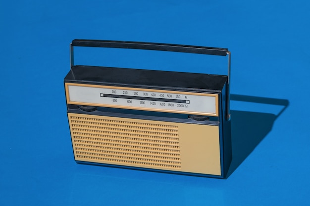 Un ricevitore per ascoltare le trasmissioni radio su sfondo blu. Trasmissione radiofonica in diretta. Tecnica vintage.