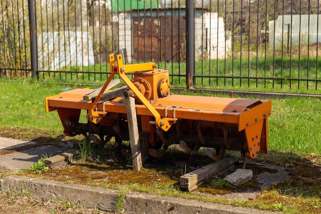 Un rimorchio coltivatore con creste e rulli si trova sul sito di un negozio che vende attrezzature agricole