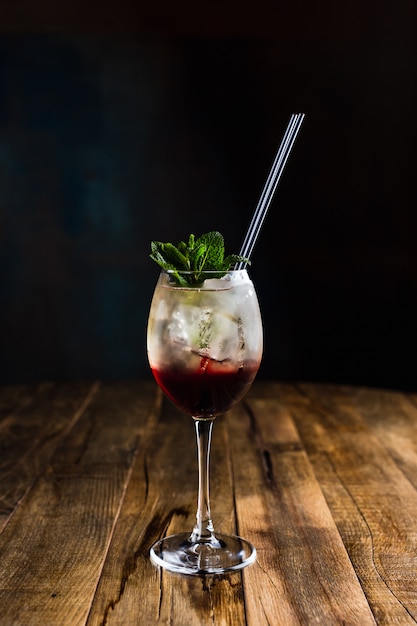 Un rinfrescante cocktail ghiacciato a strati in un bicchiere da vino guarnito con menta