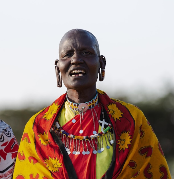 Un ritratto della donna Masai Mara in abiti tradizionali che canta una canzone. Masai Mara, Kenia