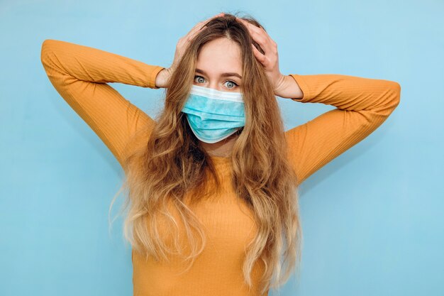 Un ritratto di Close-up di una donna in una maschera medica. Una donna spaventata. La donna ha paura di contrarre il coronavirus. COVID-2019. Una pandemia globale.