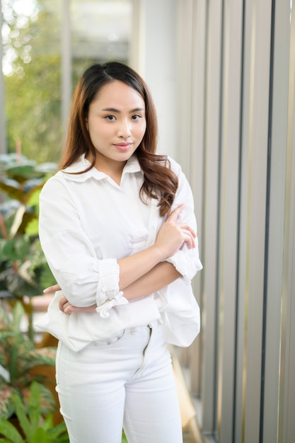 Un ritratto di donna asiatica fiduciosa di affari che indossa una camicia bianca in ufficio
