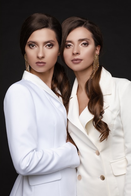 Un ritratto di due belle sorelle con trucco elegante