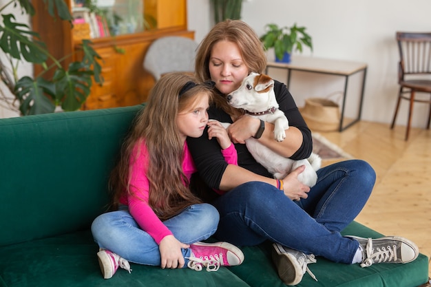 Un ritratto di due persone adorabili mamma e suo abbraccio bambino. Trascorrono il tempo libero insieme seduti in un comodo divano al chiuso. Concetto di famiglia.