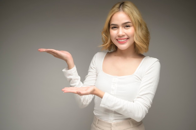 Un ritratto di giovane donna bionda su sfondo bianco studio