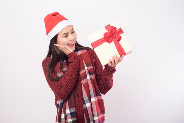 Un ritratto di giovane donna sorridente che indossa il cappello rosso di Babbo Natale isolato sfondo bianco studio.