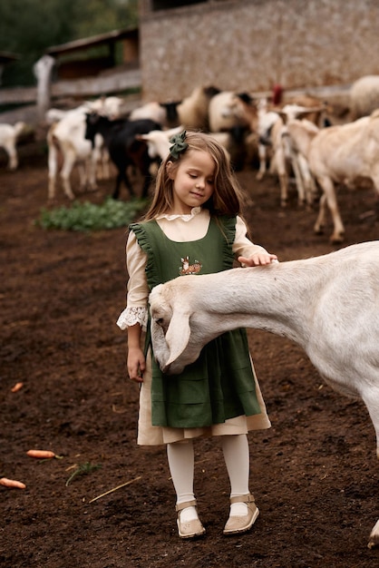 Un ritratto di un bambino carino in bellissimi abiti verdi che cammina in una fattoria