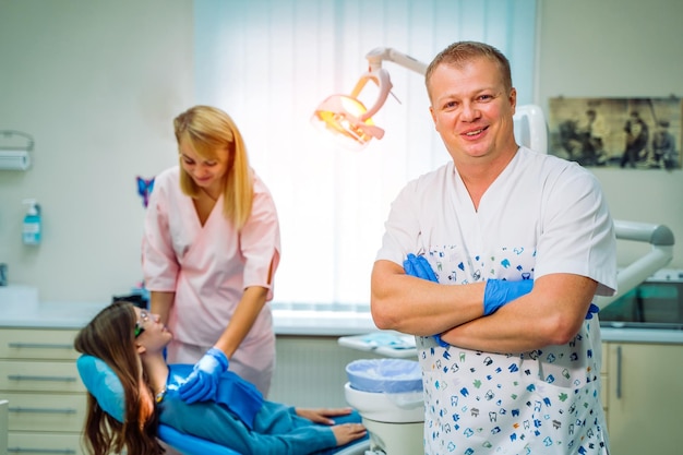 Un ritratto di un dentista con assistente che lavora in background Concetto di cura orale Stomatologia moderna