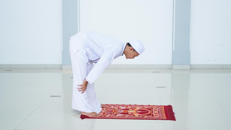 Un ritratto di un uomo musulmano asiatico prega alla moschea, il nome della preghiera è sholat, movimento rukuk