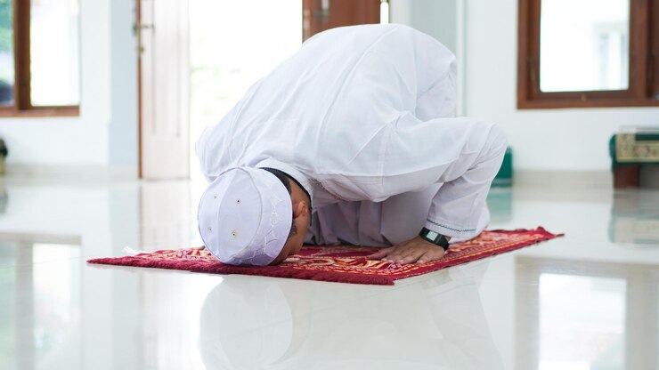 Un ritratto di un uomo musulmano asiatico prega alla moschea, il nome della preghiera è sholat, movimento sujud su sholat