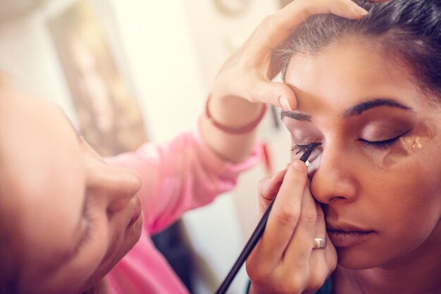 Un ritratto di una bella donna con il trucco applicato da un truccatore. Avvicinamento.
