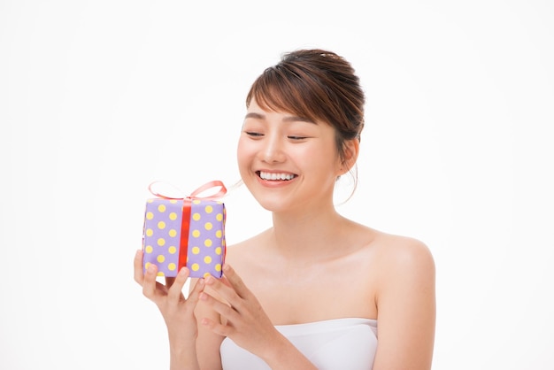 Un ritratto di una bella ragazza in possesso di un regalo isolato su sfondo bianco