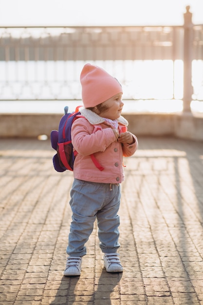 Un ritratto di una felice elegante bambina in una giacca di jeans rosa