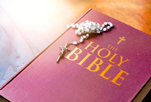 Un rosario di perle bianche con un crocifisso d'argento sopra la copertina del libro della Bibbia chiusa