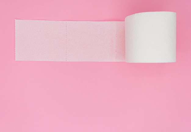 Un rotolo di carta igienica isolato su sfondo rosa Colore pastello Concetto di igiene