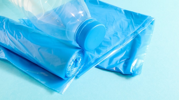 Un rotolo di sacchetti di plastica in blu su sfondo blu. Sacchetti progettati per contenere la spazzatura e utilizzati a casa e collocati in vari contenitori per la spazzatura. Copia spazio.