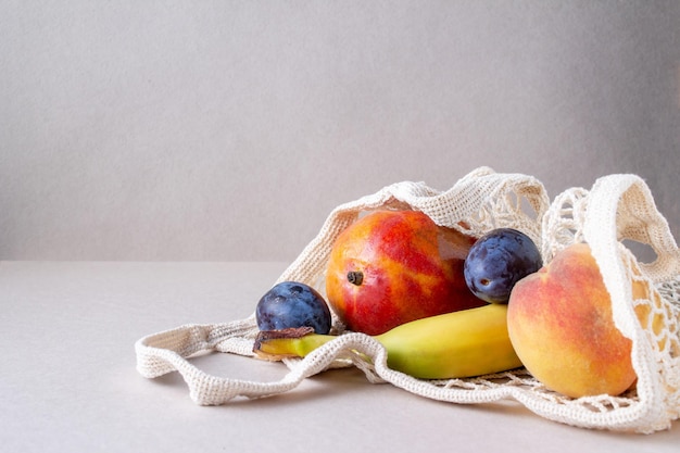 Un sacchetto di corda con frutta giace sullo spazio della copia del tavolo