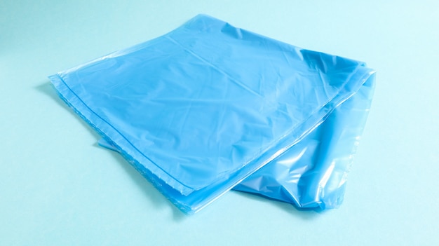 Un sacchetto di immondizia di plastica strappato in blu su sfondo blu. Una borsa progettata per contenere la spazzatura e viene utilizzata a casa e collocata in vari contenitori della spazzatura.