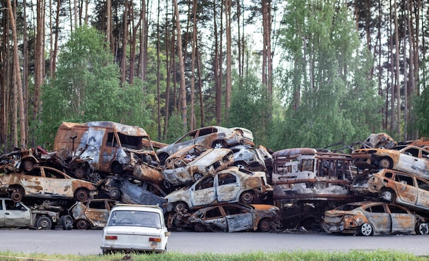 Un sacco di auto bruciate arrugginite a Irpen dopo essere state colpite dall'esercito russo Guerra della Russia contro l'Ucraina Cimitero di auto distrutte di civili che hanno cercato di evacuare dalla zona di guerra