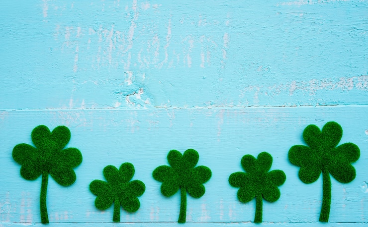 Foto un sacco di foglia di trifoglio di carta verde su sfondo bianco e blu tavolo in legno