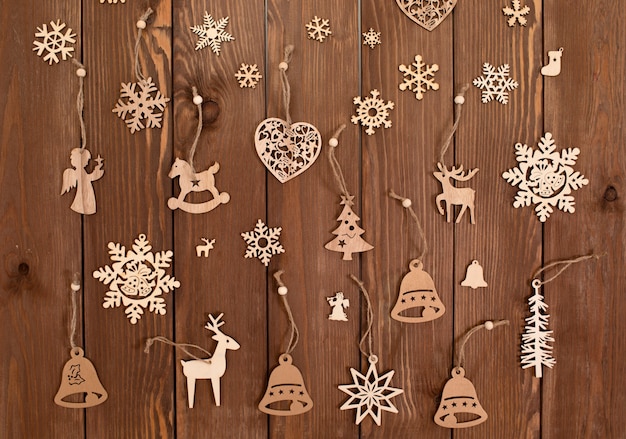 Un sacco di giocattoli in legno per albero di Natale sulla vista superiore del fondo di legno.