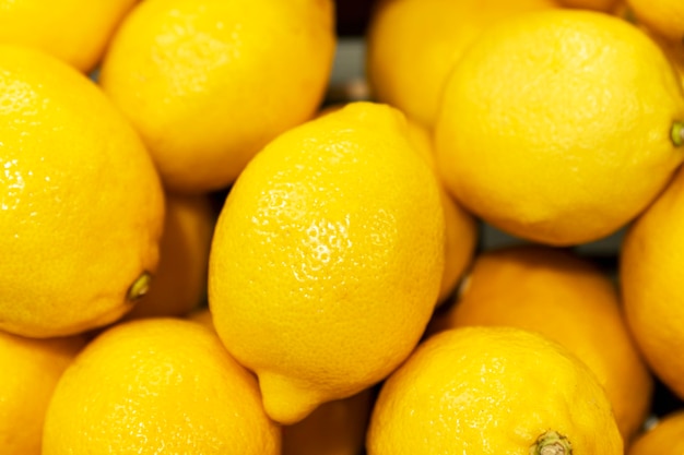 Un sacco di limoni in una scatola. Prodotto succoso e maturo. Vitamine e antiossidanti dalla natura. Avvicinamento.