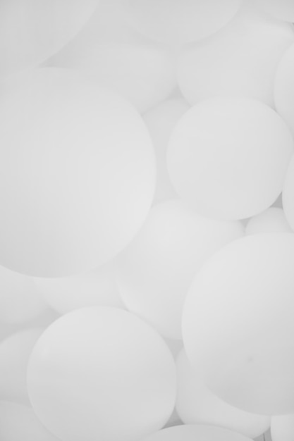 Un sacco di palloncini bianchi, sfondo. Molti palloncini bianchi, palloni gonfiabili, sfondo di cerchi bianchi e grigi. Concetto di vacanza. Sfondo astratto.Foto in bianco e nero