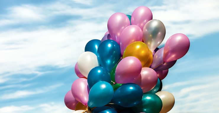 Foto un sacco di palloncini colorati sullo sfondo del cielo azzurro con nuvole