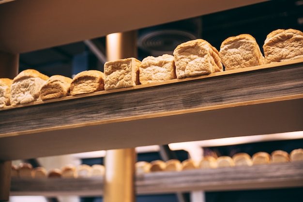 Un sacco di pane fresco pagnotta su display in legno.