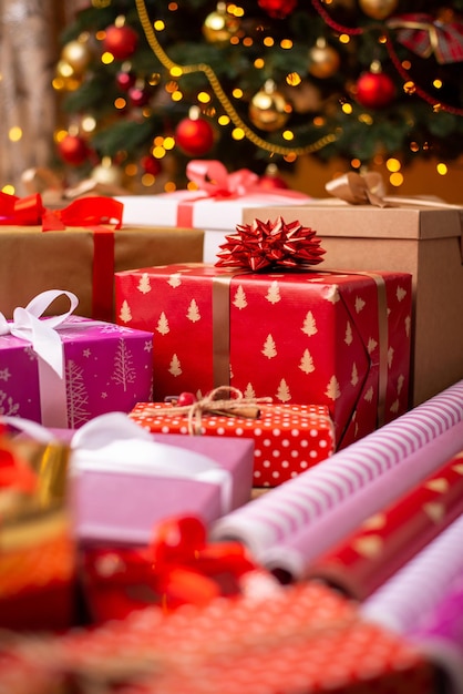 Un sacco di regali decorati vicino all'albero di Natale Interni accoglienti con un'atmosfera calda e felice per le vacanze di Capodanno