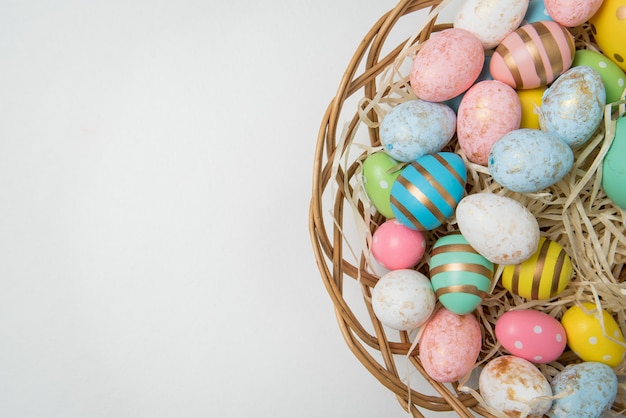 Un sacco di uova colorate di Pasqua nel carrello. Sfondo bianco. Buona Pasqua. copia spazio