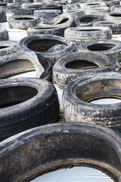 Un sacco di vecchi pneumatici per auto usate si chiudono su sfondo bianco