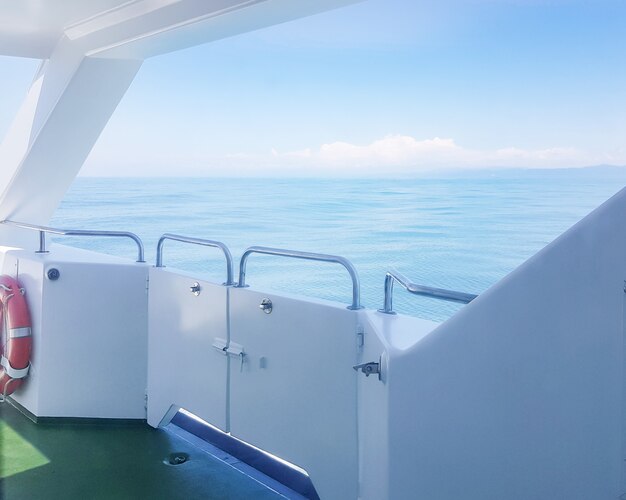 Un salvagente sul ponte di uno yacht di lusso, una vista sul mare con le onde, un sentiero sull'acqua, il concetto di una vacanza sull'acqua e un viaggio romantico
